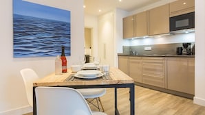 A modern kitchen with wooden cabinets, a microwave, and a coffee maker.