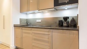 A modern kitchen with a stainless steel sink, a microwave, and a coffee maker.