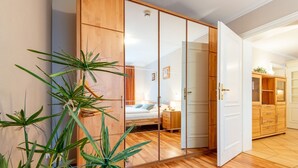 Un dormitorio con un armario de madera, una cama y una mesita de noche.