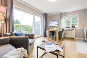 Una sala de estar moderna con sofá, mesa de centro y zona de comedor.