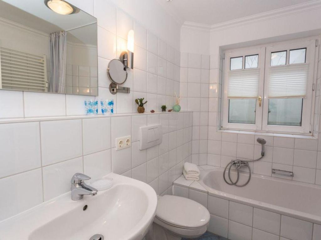 A bathroom with a sink, toilet, and bathtub.