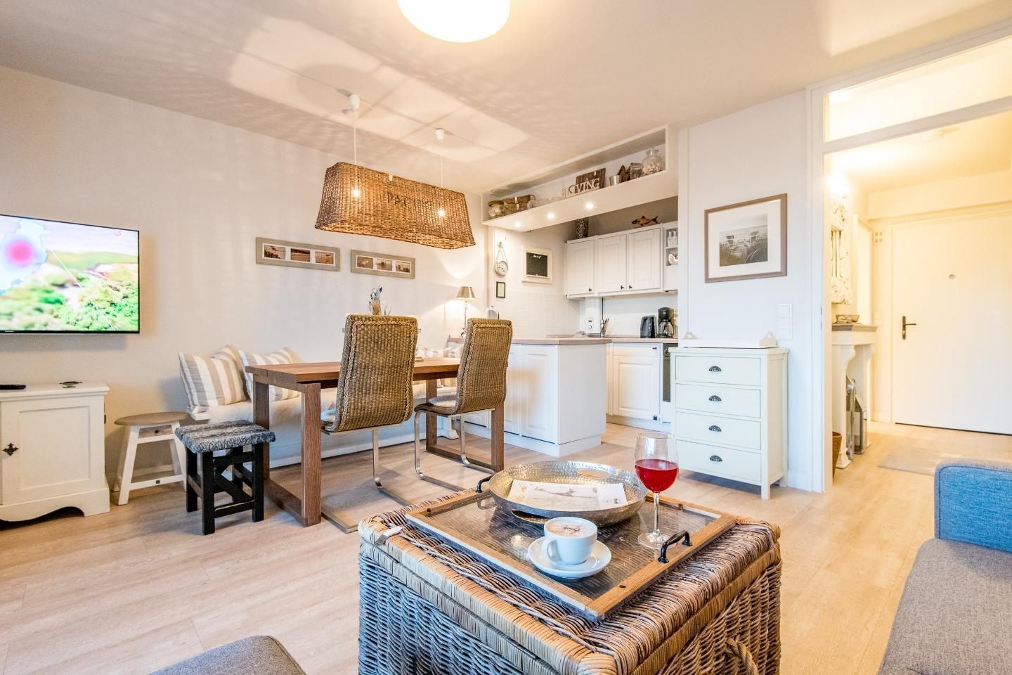 Ein modernes Wohnzimmer mit Essbereich, Küche und Fernseher.