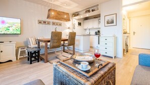 Ein modernes Wohnzimmer mit Essbereich, Küche und Fernseher.