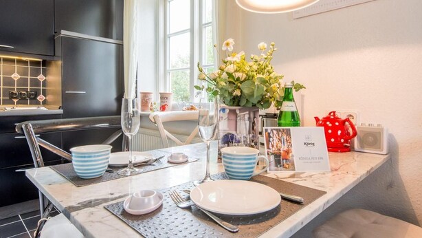 A modern kitchen with a dining area set for a meal. - Bädervilla, Whg. 28b - Bädervilla (Sylt)