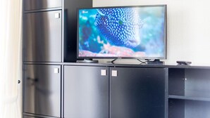 A flat-screen TV on a black entertainment unit in a room with a white wall. - Bädervilla, Whg. 28b - Bädervilla (Sylt)