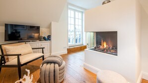 Una sala de estar moderna con chimenea, televisor y un rincón de estar acogedor.