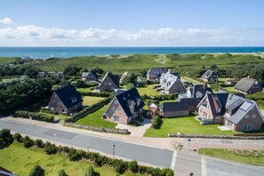 A residential area with houses featuring steep roofs and a mix of brick and stone construction. - House at Steinmannstraße 77, half of House A (Sylt)