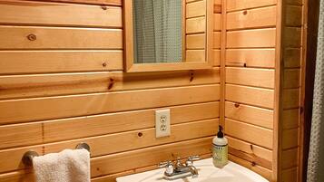 Bathtub, towels, shampoo, toilet paper