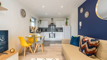 A modern apartment with a dining area, kitchen, and living room.