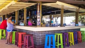A bar area with colorful stools and a counter. - OCEAN VIEW SUITE WITH FULL KITCHEN (Daytona Beach)