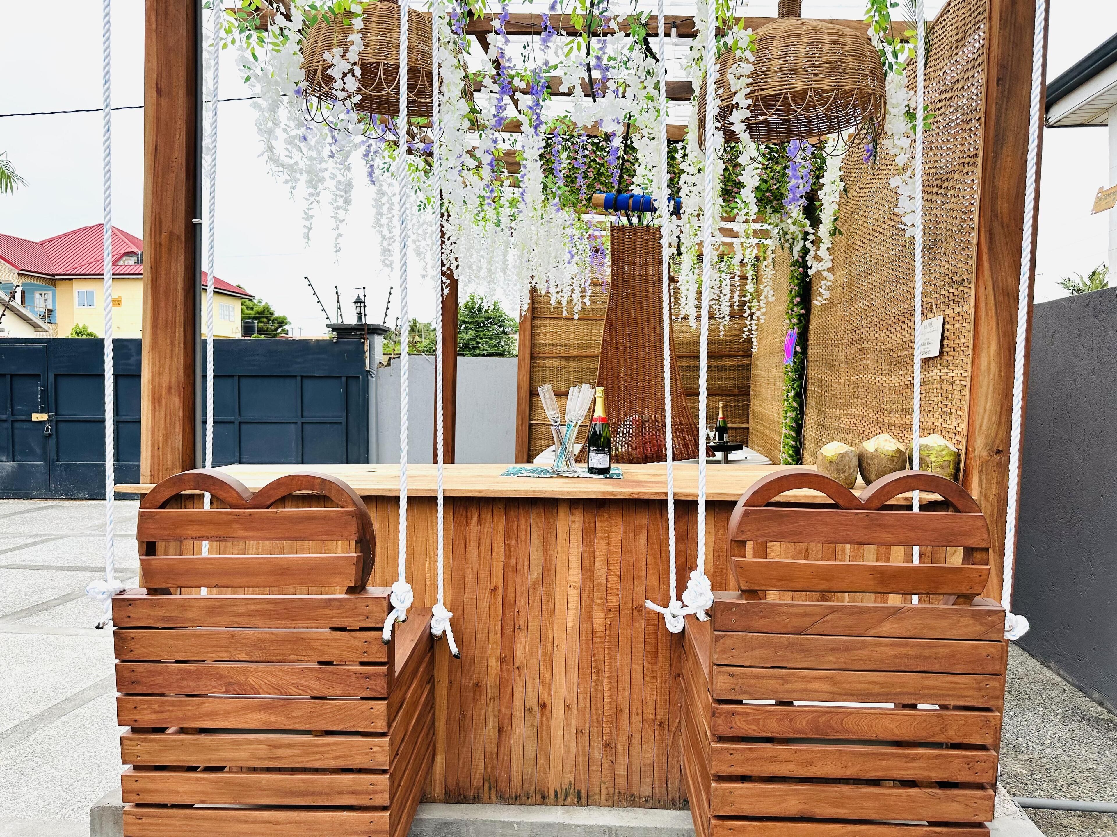 A wooden bar area with hanging baskets and a bottle of wine.