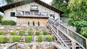 Un edificio a due piani con una veranda in legno e pareti in pietra.
