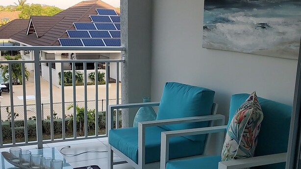 A modern living room with a sofa, coffee table, and a decorative rug. - Tastefully decorated nautical Oasis in the Richmond Estate subdivision awaits yo (St. Ann Parish)