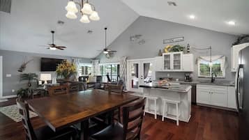 A spacious kitchen with white cabinets, a large island, and a built-in refrigerator.