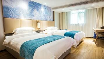 A hotel room with two beds, a desk, a chair, a large abstract painting, and a window with curtains.