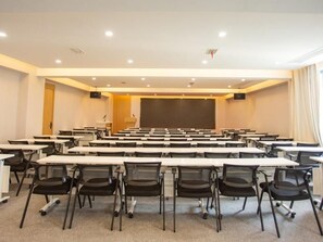 A conference room with multiple tables and chairs, a podium, and a large screen. - Greentree Eastern Hotel (Huai'an Suning Plaza Huaihai West Road) (Huai'an)