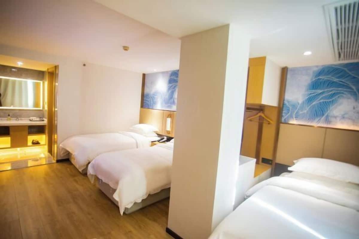 A hotel room with two beds, a walk-in closet, and artwork on the walls.