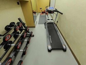 A gym with a treadmill, dumbbells, and a mirror. - Greentree Eastern Hotel (Huai'an Suning Plaza Huaihai West Road) (Huai'an)