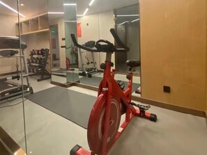 A gym with exercise equipment, including a stationary bike, a treadmill, and weights. - Greentree Eastern Hotel (Huai'an Suning Plaza Huaihai West Road) (Huai'an)