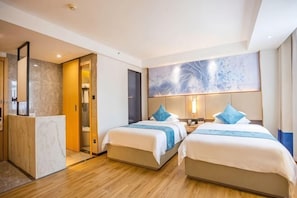 Une chambre d’hôtel avec deux lits, une salle de bain et un bureau.