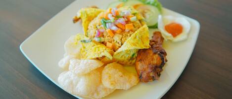 A plate of food with various items including fried items, a salad, and a small dish of sauce.