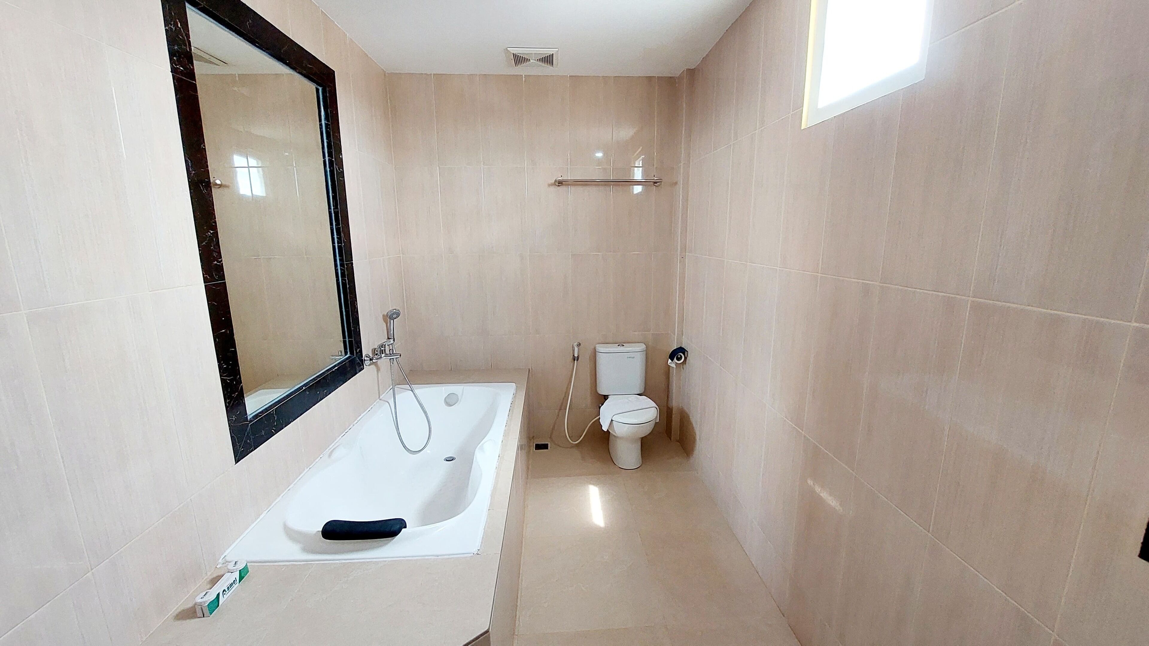 Un baño con bañera, inodoro y espejo.