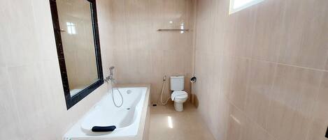 Un baño con bañera, inodoro y espejo.