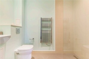 Bathroom features a toilet, shower area, and towel rack.