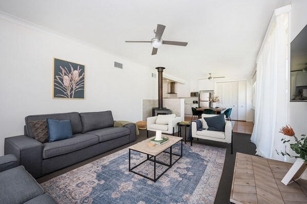 A modern living room with a grey sofa, a coffee table, and a patterned rug. - Bancroft House Mudgee by Your Innkeeper (Mudgee)