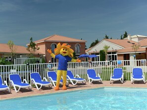 A mascot by a pool with lounge chairs and a building in the background. - Romantic Vineyard Getaway (Sallèles-d'Aude)