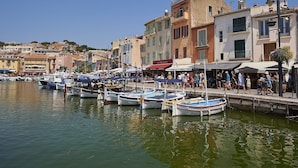 A marina with boats docked, a waterfront promenade, and buildings with balconies. - Provence Villa for Families (Nans-Les-Pins)