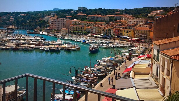 A marina with boats docked, a waterfront promenade, and buildings with red-tiled roofs. - Provence Villa for Families (Nans-Les-Pins)