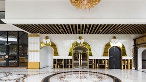 A luxurious lobby with a marble floor, a central reception desk, and ornate gold detailing. - Arte Mont Kiara Managed by Airhost (Kuala Lumpur)
