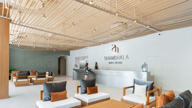 A modern hotel lobby with a reception desk, seating areas, and a wooden ceiling. - Shambhala Hotel Pattaya (Pattaya)