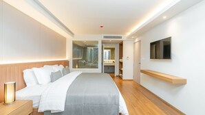 A modern hotel room with a large bed, bedside table, and a mounted TV. - Shambhala Hotel Pattaya (Pattaya)
