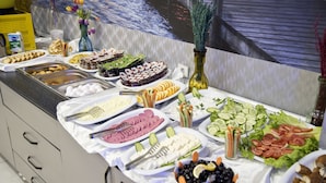 Een buffet met diverse gerechten, zoals fruit, groenten en kazen.