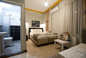 A bedroom with a bed, bedside table, and a view of the bathroom. - Golden Horn Park Hotel (Istanbul)