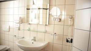 A bathroom with a white sink, a mirror, a towel rack, and a hairdryer. - Room in Guest Room - Spacious Double Room in Alba (Alba)