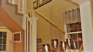 A staircase with a handrail, a window with curtains, and a wall-mounted picture frame. - The Bungalow at Grand Forks (Grand Forks)