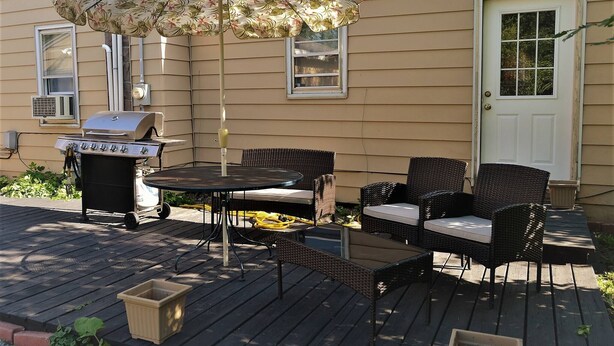 A patio with outdoor furniture, a grill, and an umbrella. - The Bungalow at Grand Forks (Grand Forks)