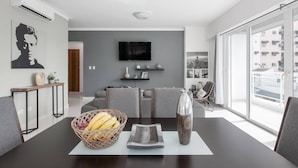 A modern dining area with a dark wooden table, a basket of bananas, and a decorative vase. - Luxurious Apartment In The Heart Of Santo Domingo (Santo Domingo)