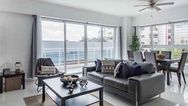 A modern living room with a sofa, coffee table, and dining area. - Luxurious Apartment In The Heart Of Santo Domingo (Santo Domingo)