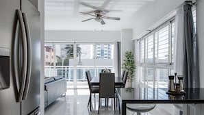 A modern kitchen with a dining area, large windows, and a ceiling fan. - Luxurious Apartment In The Heart Of Santo Domingo (Santo Domingo)