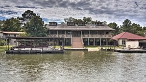 A two-story building with a covered dock and a small boat. - Waterfront Listing - 3 Bedroom 3 Bath on Secluded Private Cove,great Location (Hot Springs)