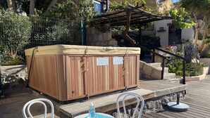 A wooden hot tub with a beige cover, two white chairs, and a table with a blue mat. - Cottage With 3 Bedrooms, 2 Bathrooms, Heated Solar Pool, Sauna, Jacuzzi, Garden (Guia de Isora)