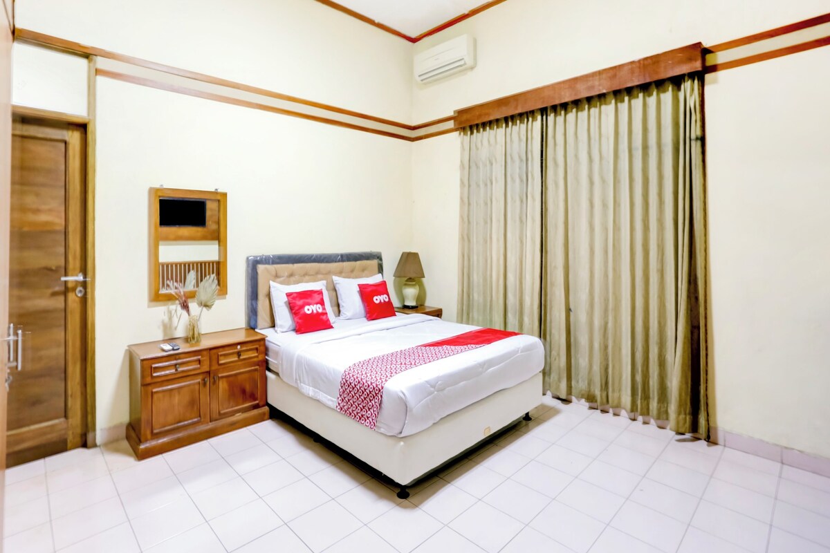 A neatly arranged bedroom with a bed, bedside table, and a mirror.