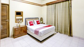 A neatly arranged bedroom with a bed, bedside table, and a mirror. - Capital O 90066 Tobana Pejaten House (Jakarta)