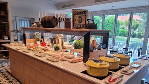 Un buffet de petit-déjeuner proposant une variété d’aliments et un espace dédié aux boissons chaudes, notamment au café.