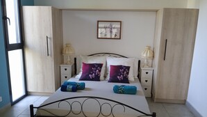 Une chambre bien rangée, avec un lit, deux tables de chevet, une fenêtre et une armoire.