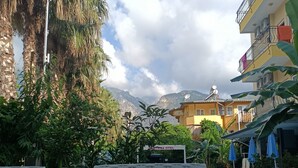 A table with a meal and a view of a pool and mountains. - Santana Hotel (Kemer)